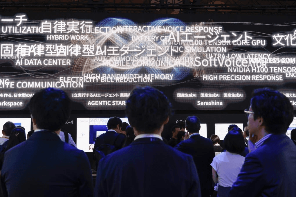 일본 AI 전시회에서 관람객들이 일본어·영어 AI 키워드가 흐르는 대형 LED 스크린을 뒤에서 바라보고 있는 모습