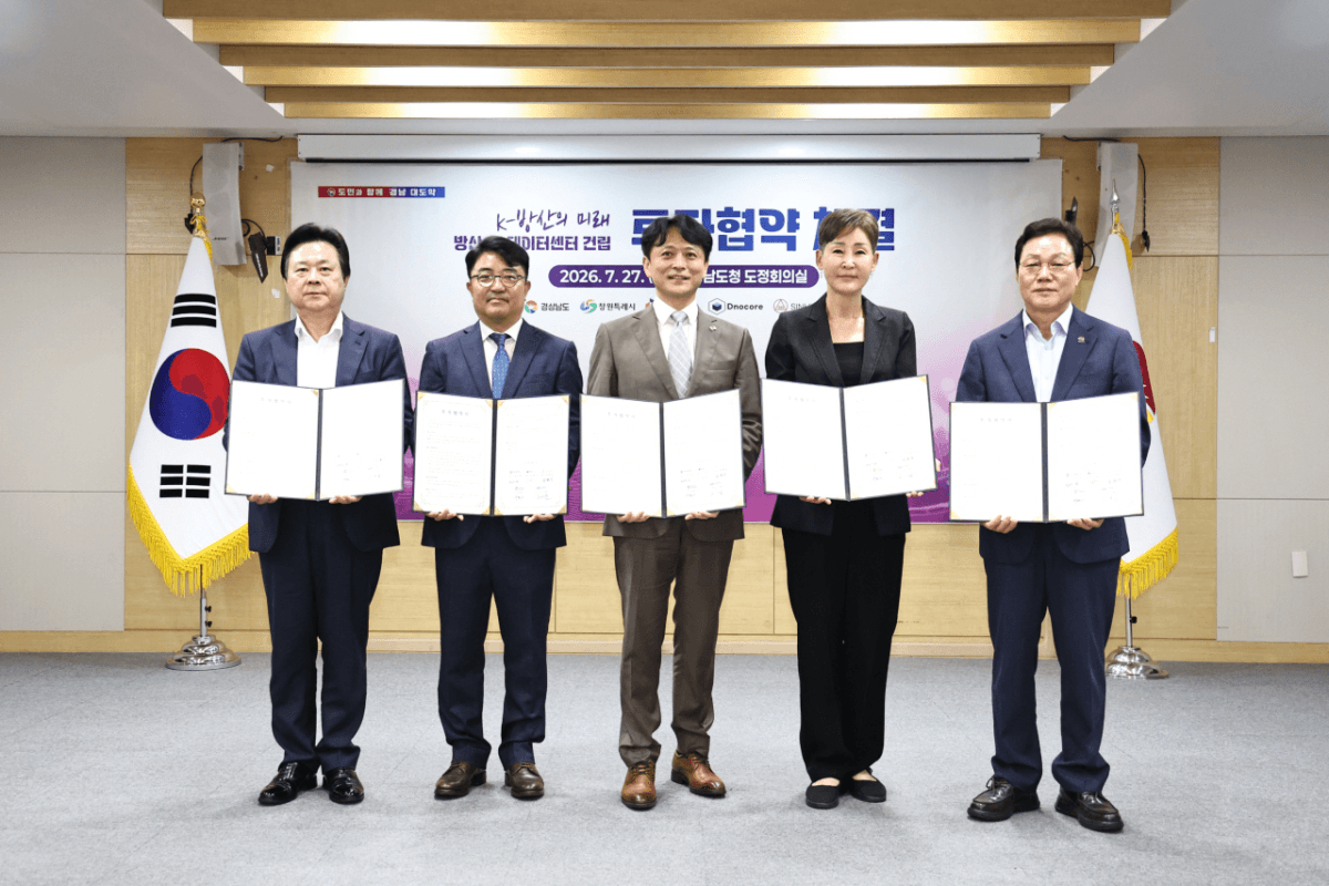 경남도청 도정회의실에서 열린 창원 방산 전용 AI 데이터센터 투자협약 체결식 — 참석자 5명이 협약서를 들고 서 있다