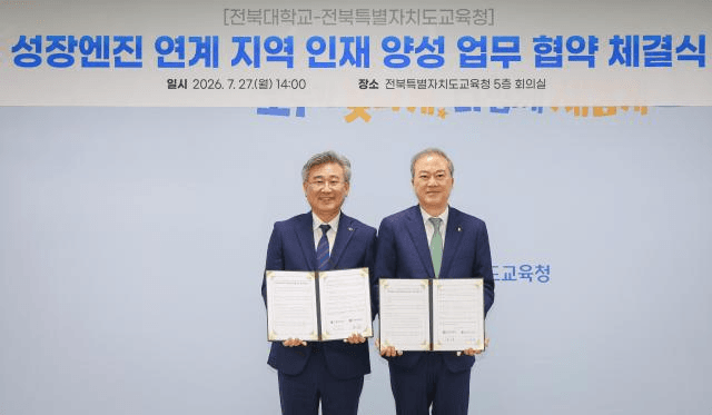 '성장엔진 연계 지역 인재 양성 업무 협약 체결식' 배경 화면 앞에서 협약서를 펼쳐 든 전북교육청·전북대 협약식 현장