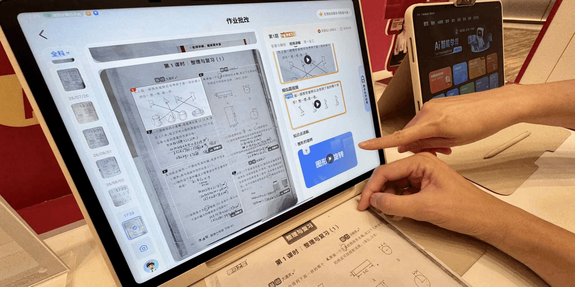 매장에 전시된 중국 AI 학습기기 화면 — 숙제 답안지를 스캔해 자동 채점하고 풀이 영상을 띄운 태블릿 UI를 손가락으로 조작하는 모습