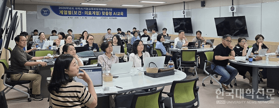 동신대 교수학습센터의 '계열별(보건·의료계열) 맞춤형 AI교육' 강의실 전경. 노트북을 펼친 교원들이 정면 스크린을 보고 있고, 앞쪽 배너에 2026학년도 대학 AI기본교육과정 개발지원사업 문구가 적혀 있다.