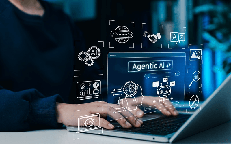 노트북을 사용하는 손 위로 'Agentic AI' 검색창과 AI 아이콘들이 떠 있는 개념 이미지