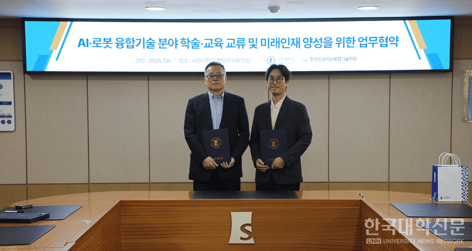 서원대와 한국인공지능융합기술학회가 'AI·로봇 융합기술 분야 학술·교육 교류 및 미래인재 양성을 위한 업무협약' 배경 화면 앞에서 협약서를 들고 있는 모습