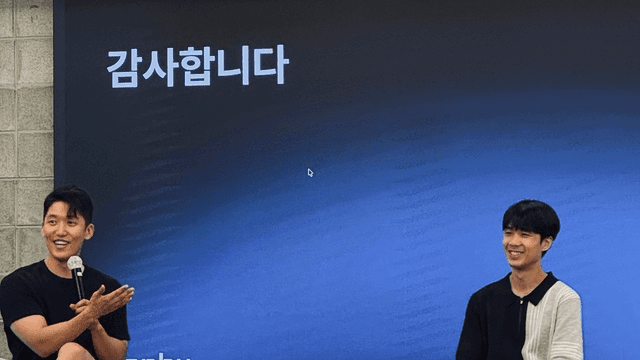 '감사합니다' 슬라이드를 배경으로 마이크를 들고 대담 중인 파이어사이드 챗 현장 사진