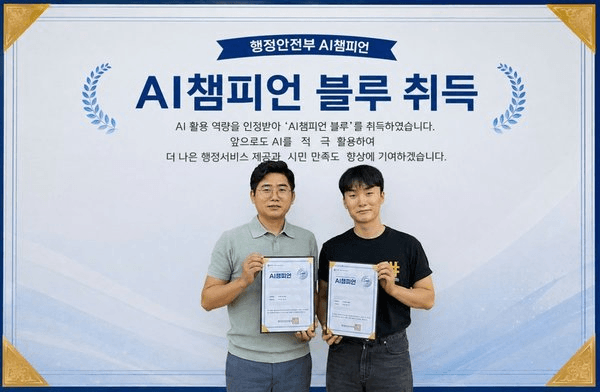 '행정안전부 AI챔피언 / AI챔피언 블루 취득' 문구가 적힌 배너 앞에서 광양시 생애복지플랫폼팀 공무원 두 명이 각자 인증서를 들고 서 있다.