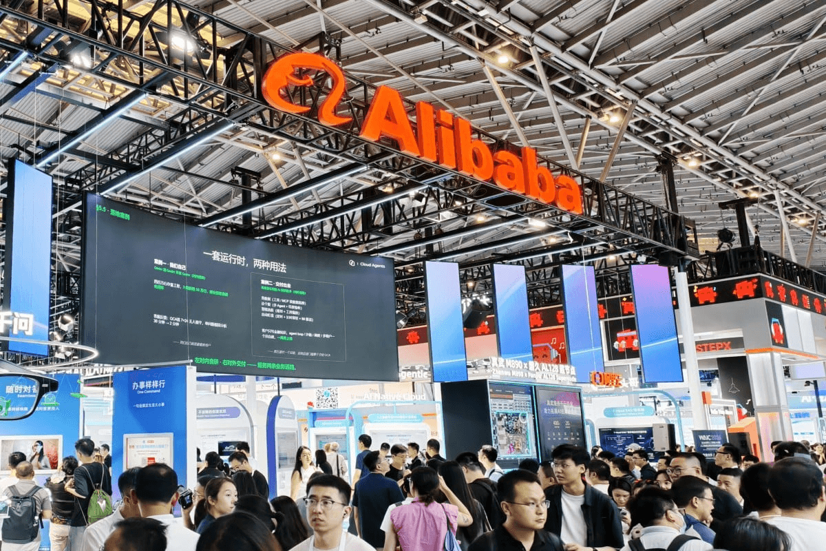 대형 전시장 천장에 걸린 알리바바(Alibaba) 로고 아래로 관람객이 가득 찬 부스 전경. 스크린에 클라우드·AI 에이전트 관련 중국어 설명이 표시돼 있다