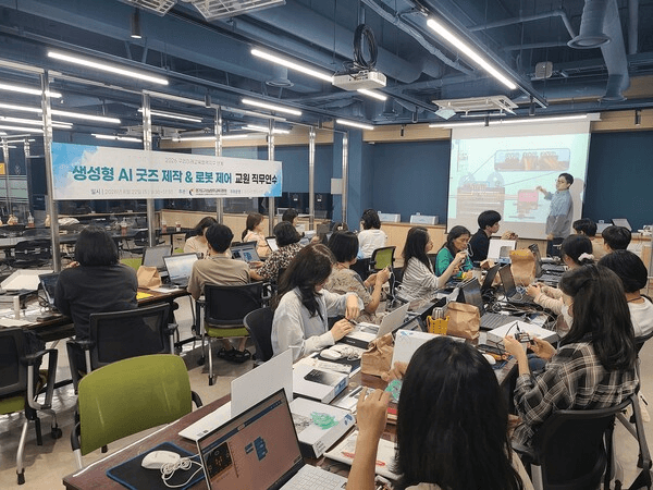 인창도서관 메이커 공간에서 교원들이 노트북을 놓고 앉아 '생성형 AI 굿즈 제작 & 로봇 제어 교원 직무연수' 현수막 아래 강사의 시연 화면을 보는 연수 현장 사진
