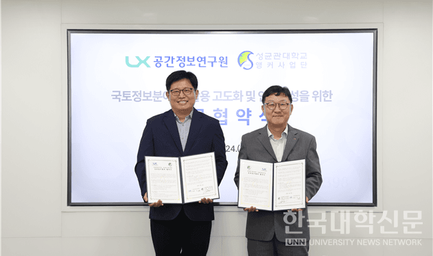 성균관대 앵커사업단과 LX공간정보연구원의 업무협약 체결식 사진. 두 참석자가 서명한 협약서를 펼쳐 들고 나란히 서 있으며, 뒤편 스크린에는 'LX 공간정보연구원'과 '성균관대학교 앵커사업단' 로고, '국토정보분야 AI 활용 고도화 및 인재양성을 위한 업무협약식' 문구가 표시돼 있다.