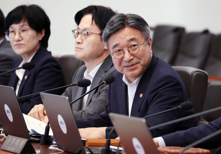 회의장 테이블에 노트북과 마이크를 앞에 두고 나란히 앉은 정부 인사들. 오른쪽 인물이 고개를 돌려 발언하고 있다