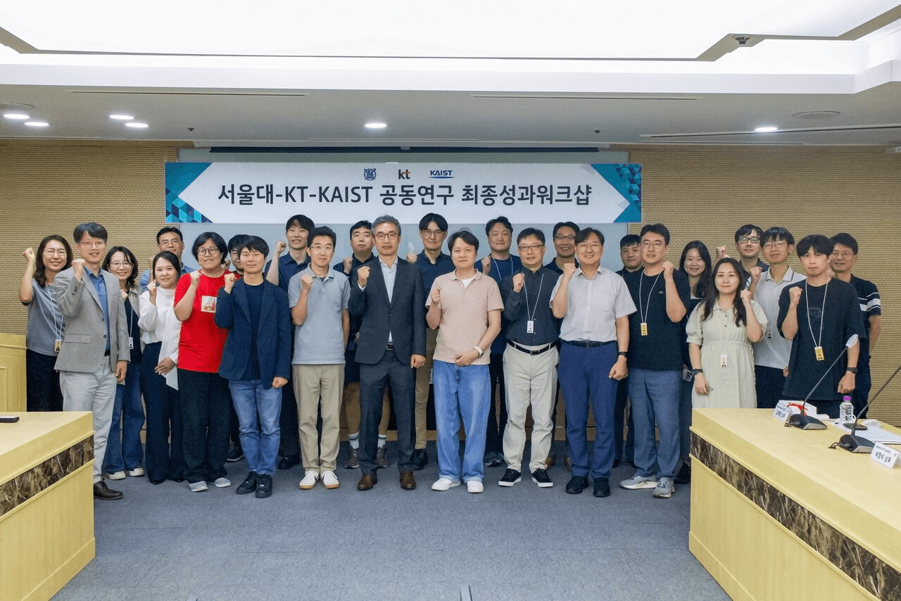 '서울대-KT-KAIST 공동연구 최종성과워크샵' 현수막 앞에서 3개 기관 연구진이 단체로 주먹을 쥐어 보이며 기념 촬영을 하고 있다