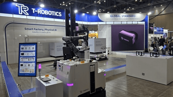티로보틱스 전시 부스 전경 — 'Smart Factory, Physical AI' 문구 아래 자율주행 물류로봇(AMR)과 협동로봇 팔이 배치된 자동화 라인 데모