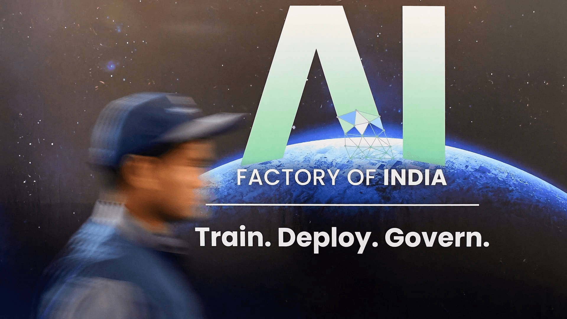 뭄바이 글로벌 핀테크 페스트의 "AI Factory of India" 전시 패널 앞을 지나는 관람객