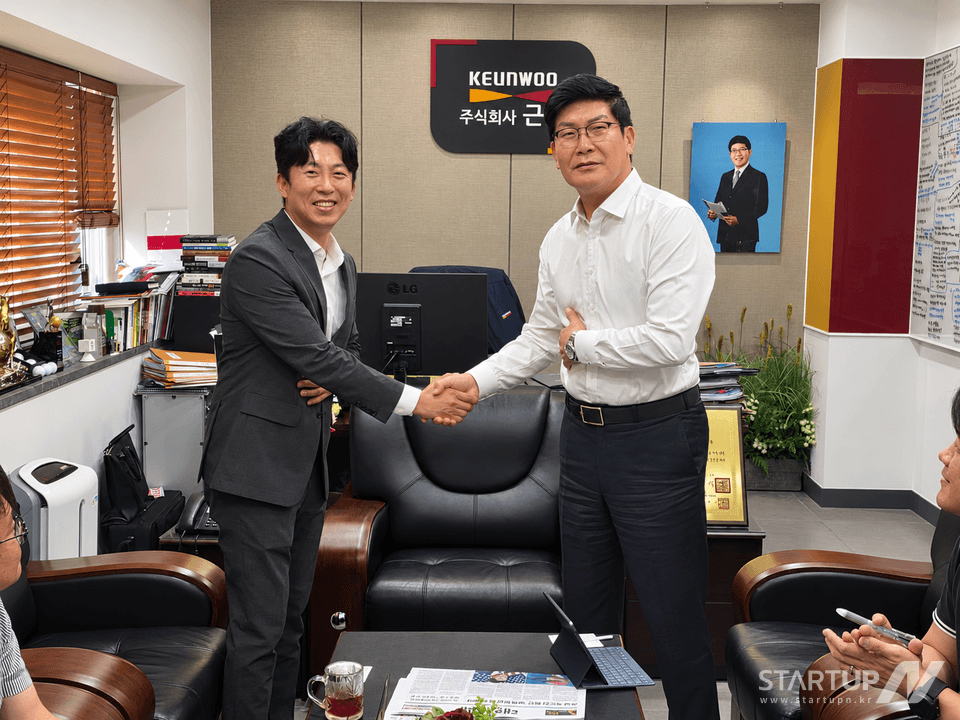 모멘트큐브 관계자들이 협력 기관 사무실에서 악수하는 모습