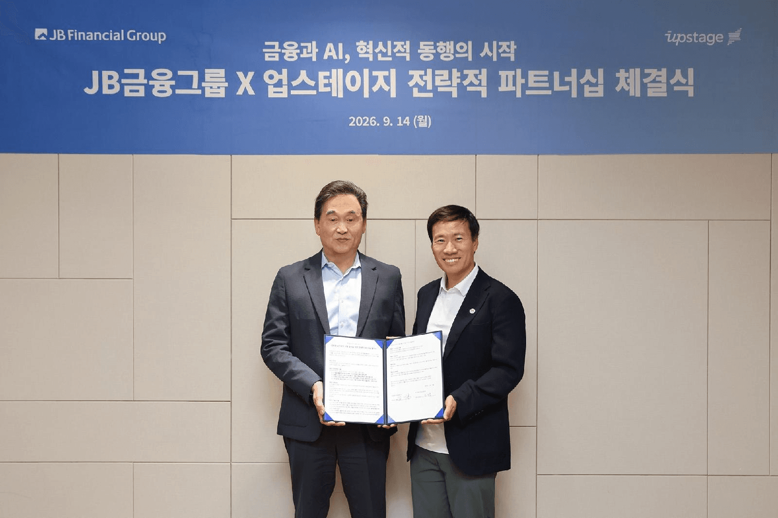 JB금융그룹과 업스테이지 전략적 파트너십 체결식에서 양사 대표가 협약서를 들고 기념촬영하는 모습 (2026년 9월 14일)